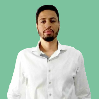 Antonio Coelho em fotografia três por quatro veste camisa manga comprida branca de botões, cabelos curtos, barba aparada mais cheia no queixo e olhar sereno